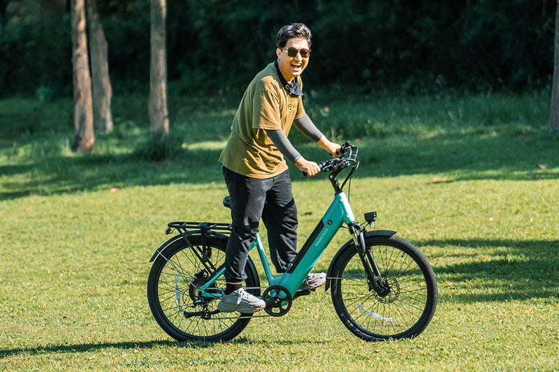 Rider using teal Magicycle CT-1 commuter ebike on a sunny day outdoors