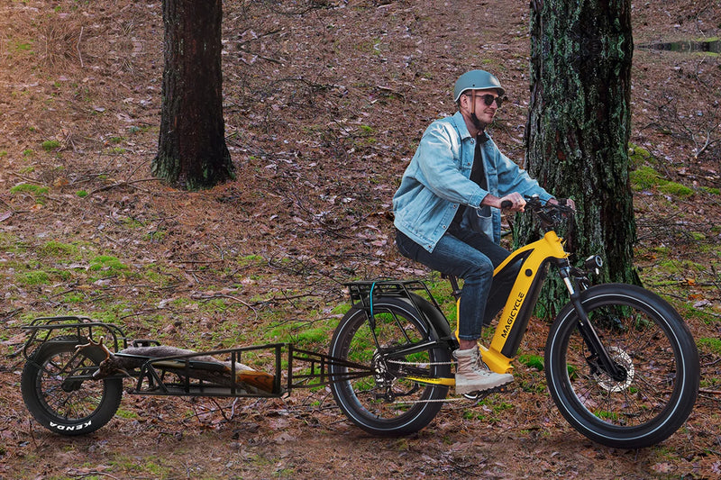 Rider on yellow Magicycle Deer ebike on forest trail with detachable trailer.