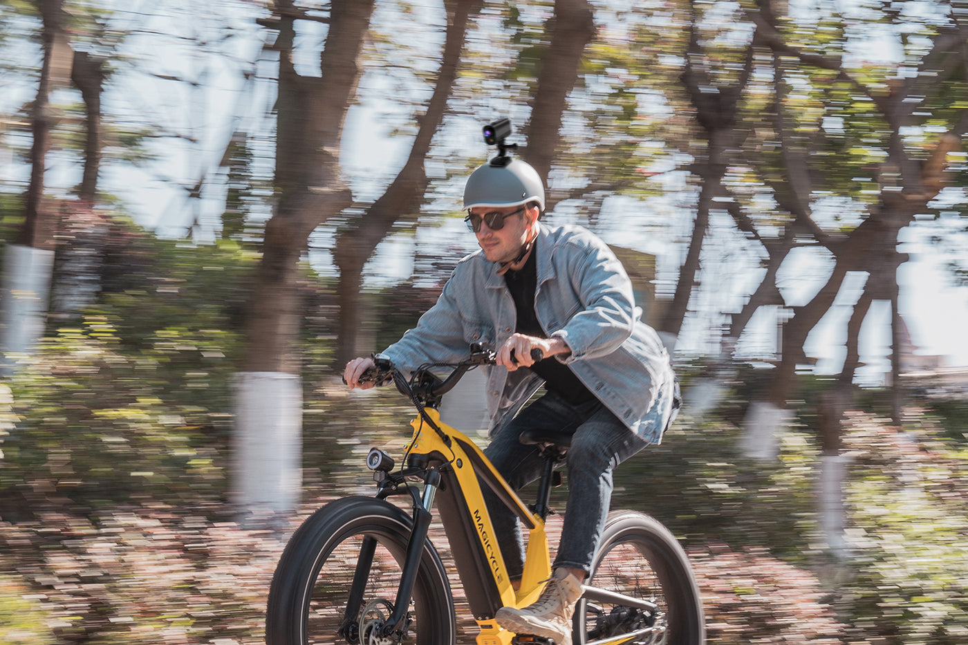 Rider on yellow e-bike with action camera mounted on helmet during a cycling session