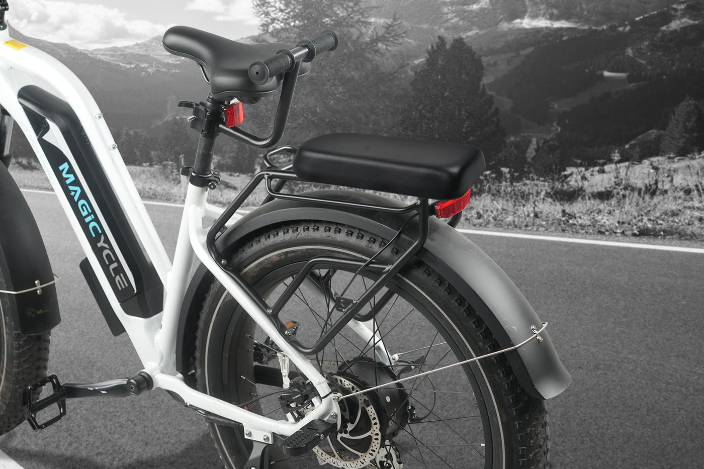 Magicycle eBike rear seat with cushion and armrest on mountain backdrop.