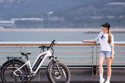 Woman in cap beside Magicycle electric bike near waterfront